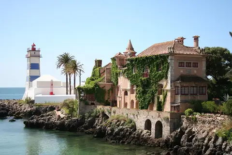 Casa de Santa Maria junto ao mar, em Cascais, com o farol de Santa Marta ao fundo