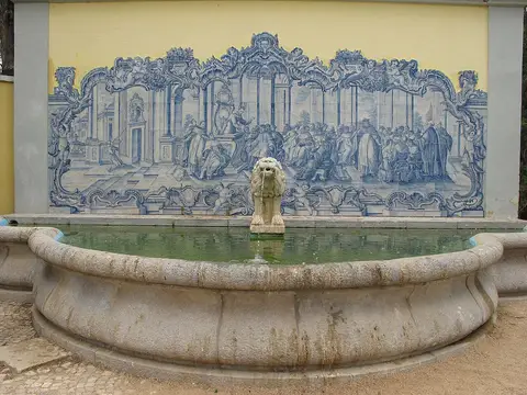 Fonte com lago e leão de pedra diante de painel de azulejos azuis no Museu Condes de Castro Guimarães