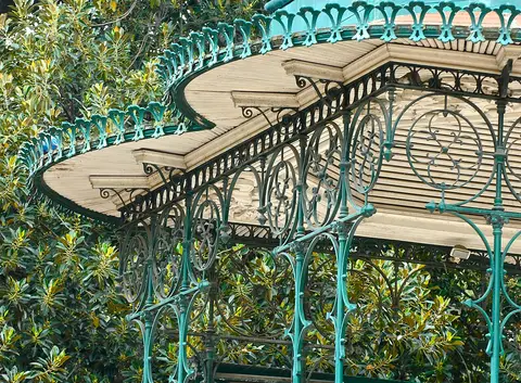 Pormenor do coreto de ferro verde do Jardim da Estrela, em Lisboa, rodeado de árvores