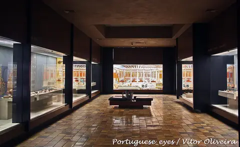 Sala de exposição do Museu Monográfico de Conímbriga com vitrinas e painéis ilustrados
