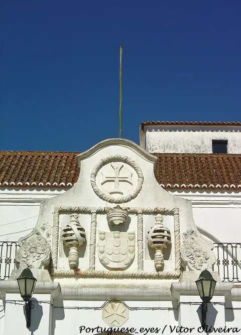 Frontão branco com brasão real e cruz de Malta na fachada do Convento das Maltezas, Estremoz