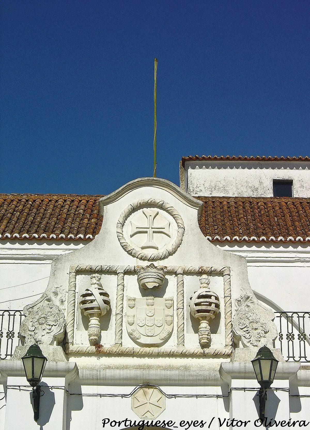 Frontão branco com brasão real e cruz de Malta na fachada do Convento das Maltezas, Estremoz