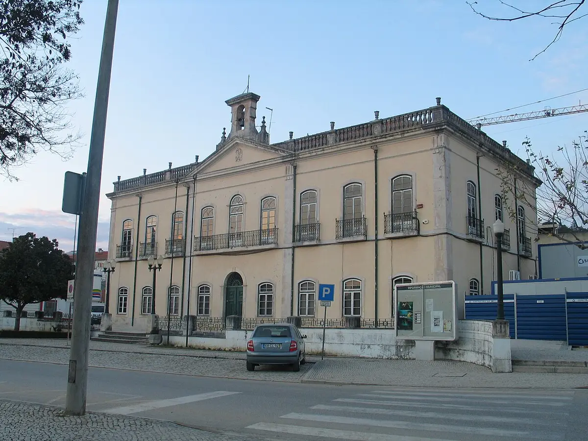 Edifício histórico dos Paços do Concelho de Ourém, com fachada clara e campanário, visto da rua