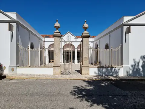 Fachada branca do Museu Etnográfico de Serpa com portão de ferro e pilares de pedra