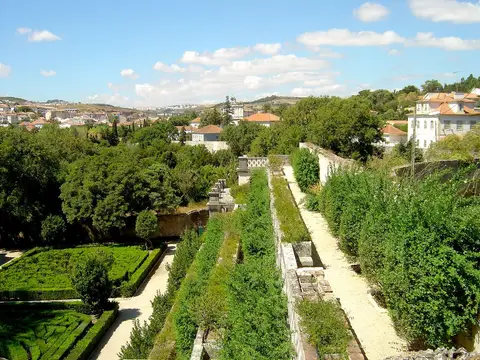 Vista sobre os jardins formais da Quinta Real de Caxias, com sebes recortadas e casario ao fundo