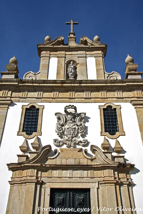 Fachada barroca da Igreja da Ordem dos Terceiros, em Ponte de Lima, com brasão de pedra e cruz no topo