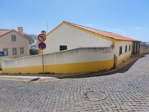 Fachada lateral branca e amarela da Casa Museu Afonso Lopes Vieira, junto a rua em calçada