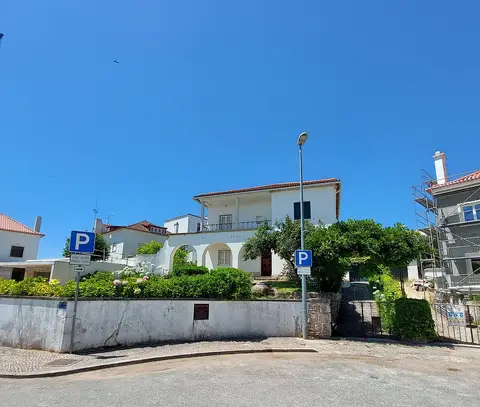 Casa-Museu Miguel Torga, edifício branco com arcadas e jardim, visto da rua sob céu azul