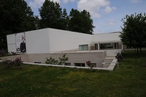 Edifício moderno branco do Centro de Estudos Camilianos, rodeado de relva e árvores
