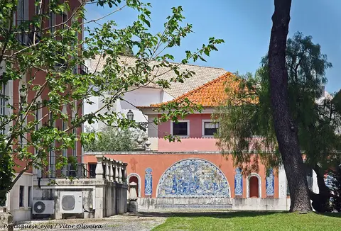 Edifício rosa com painel de azulejos e telhado laranja no Jardim da Quinta de Santa Clara, em Lisboa