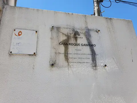 Placa identificativa da Casa Roque Gameiro com horários, na parede branca exterior do museu