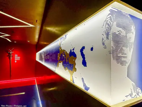 Sala expositiva do museu PO.RO.S com painel iluminado com mapa do Império Romano e perfil estilizado