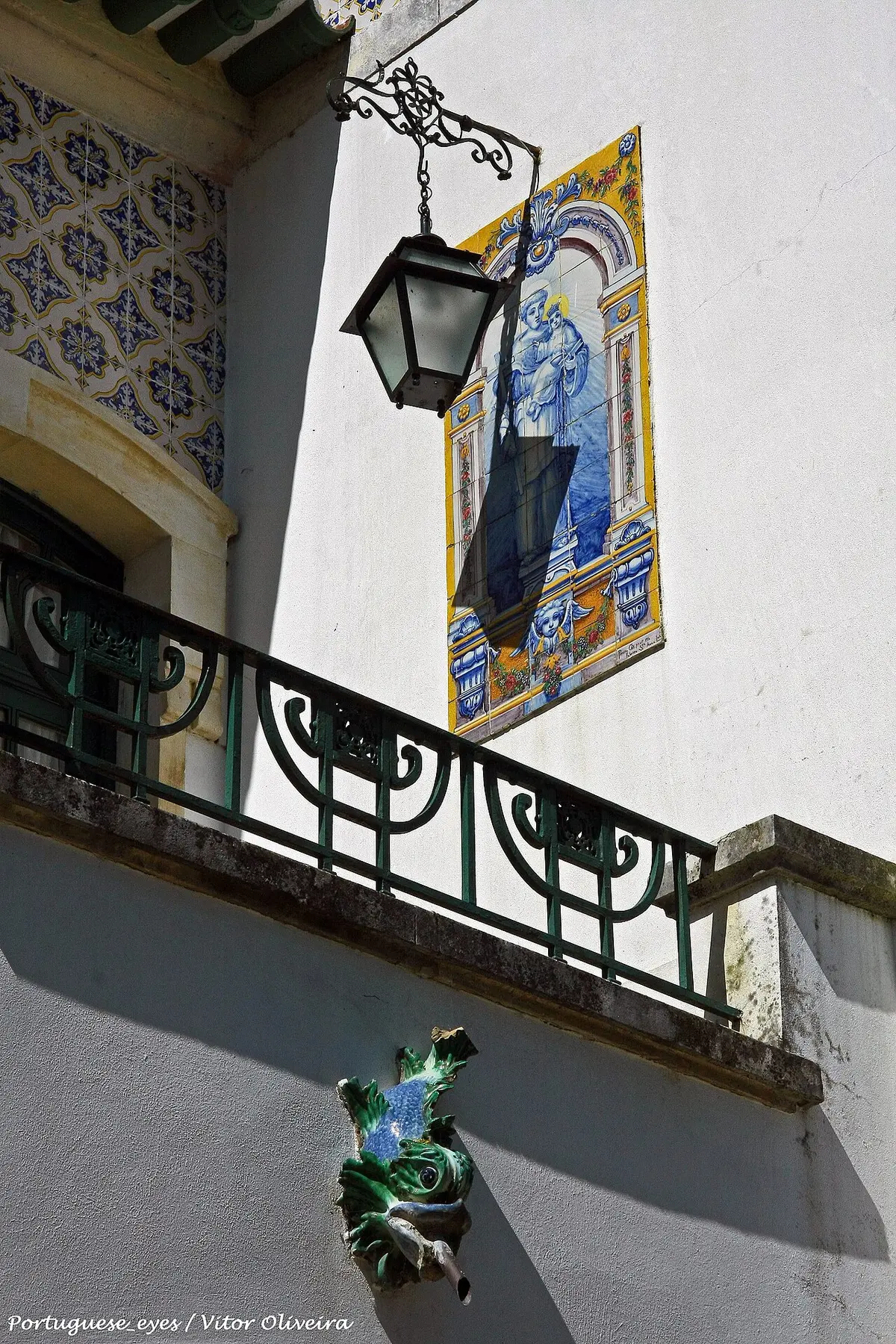 Pormenor da fachada da Casa-Museu de Egas Moniz com painel de azulejos, lanterna de ferro e varanda verde