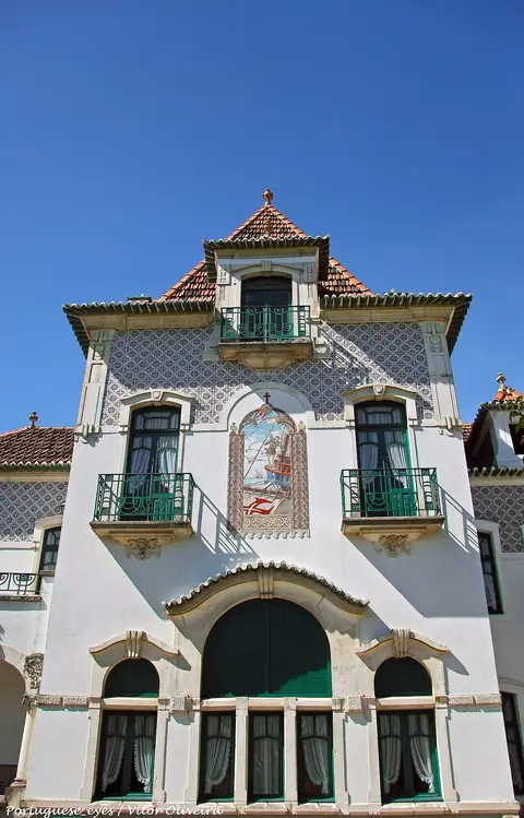 Fachada da Casa-Museu de Egas Moniz, em Avanca, com azulejos, varandas verdes e painel decorativo.
