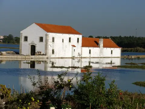 Moinho de Maré de Corroios, edifício branco com telhado vermelho rodeado de água