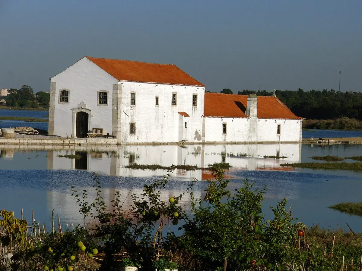 Moinho de Maré de Corroios, edifício branco com telhado vermelho rodeado de água