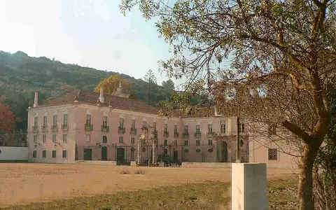 Fachada rosada do Palácio do Correio-Mor, em Loures, com encosta arborizada ao fundo
