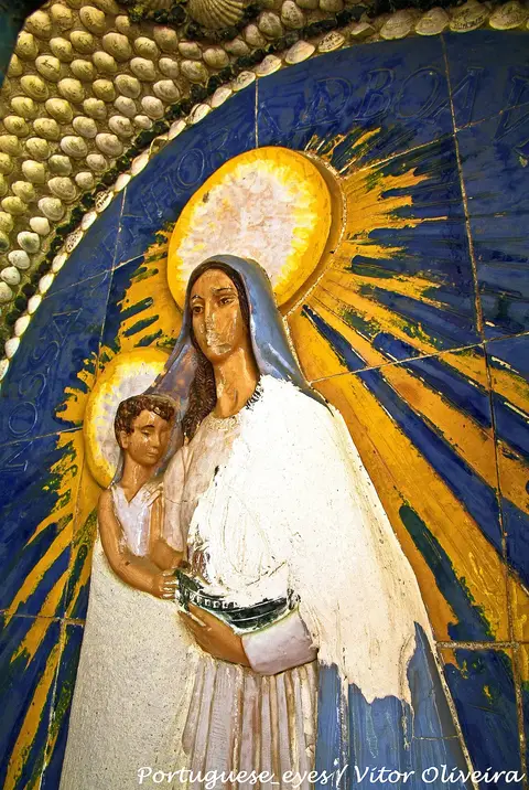 Painel religioso em relevo colorido com Nossa Senhora e o Menino, rodeado de conchas, no Convento dos Capuchos