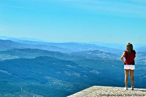 Miradouro da Senhora da Graça com vista ampla sobre serras azuladas e uma pessoa de costas