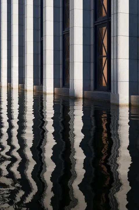 Colunas da fachada do edifício da Caixa refletidas no espelho de água do jardim