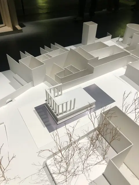 Maquete branca de templo romano e edifícios em exposição num museu de arquitetura
