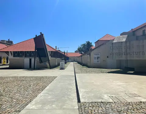 Exterior da Casa da Arquitectura, com pavilhões de telhado vermelho e letreiro em betão