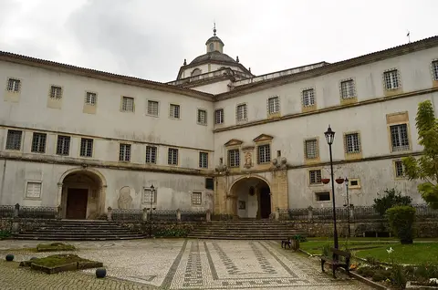 Fachada do Mosteiro de Lorvão com cúpula ao fundo e pátio em calçada portuguesa
