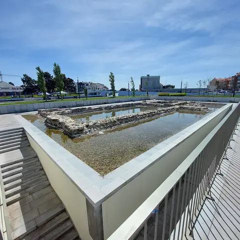 Ruínas arqueológicas preservadas ao ar livre na Praça do Rossio, em Aveiro, com guardas metálicas e escadaria