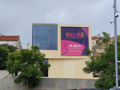 Fachada do Quake - Centro do Terramoto de Lisboa com grande cartaz cor-de-rosa e roxo