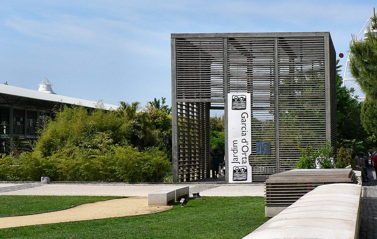 Entrada do Jardim Garcia d'Orta com estrutura de ripados de madeira, letreiro e relva